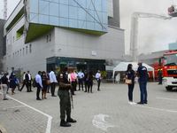 Workers of Access Bank branch stand outside the building, during a fire out break at Access Bank branch on Adetokunbo Ademola Street in Vict...