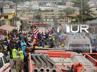 Crowd gather amidst debris of a Quorom helicopter crash, a helicopter operated by Quorom Aviation which crashed in 16A Salvation Road, Opebi...