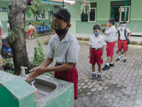 A student wash his hands before entering the classroom at Candirejo Elementary School, Semarang Regency, Central Java, Indonesia, on Septemb...