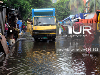Commuters make their way along a waterlogged street following monsoon rainfalls in Dhaka, Bangladesh, on September 1, 2020  (