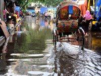 Commuters make their way along a waterlogged street following monsoon rainfalls in Dhaka, Bangladesh, on September 1, 2020  (