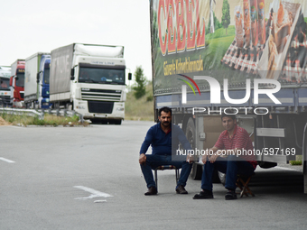 Two Turkish drivers are having a coffee on an improvised table while waiting to cross the Bulgarian-Turkish border on May 20, 2015 (