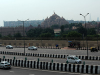 Commuters wait for a bus near the iconic Akshardham temple on a hot sunny day in New Delhi on September 6, 2020. With social distancing prot...