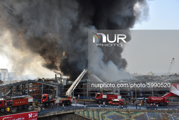 Lebanese firefighters try to put out a fire that broke out at Beirut's port area, on September 10, 2020. Thick black columns of smoke rose i...