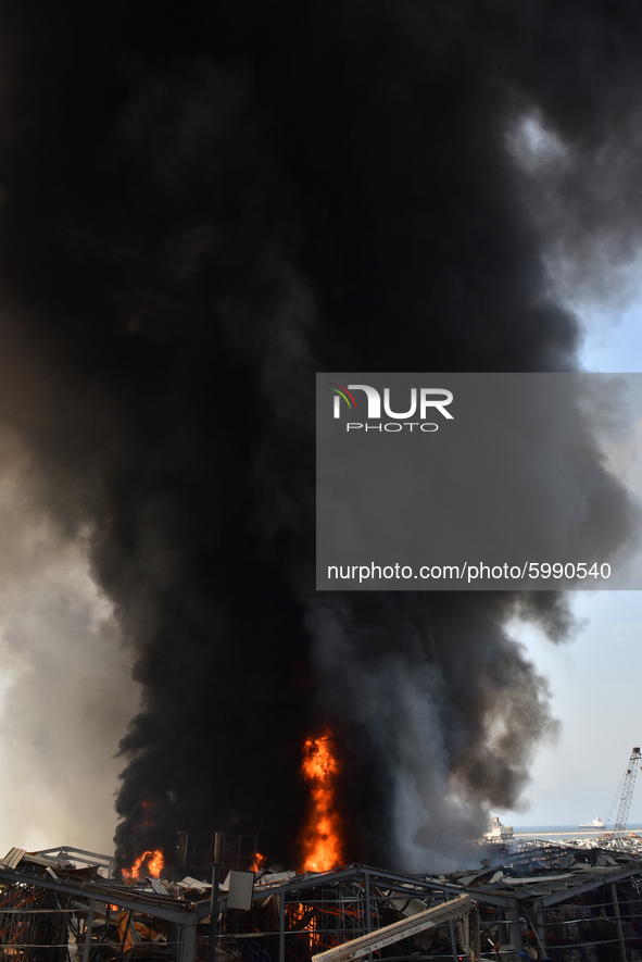 Lebanese firefighters try to put out a fire that broke out at Beirut's port area, on September 10, 2020. Thick black columns of smoke rose i...