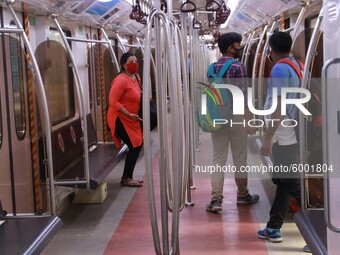 Passengers wearing a face mask walk at the platform to board a train at Noyapara Metro Station as KOLKATA METRO RAIL CORPORATION  resume ope...