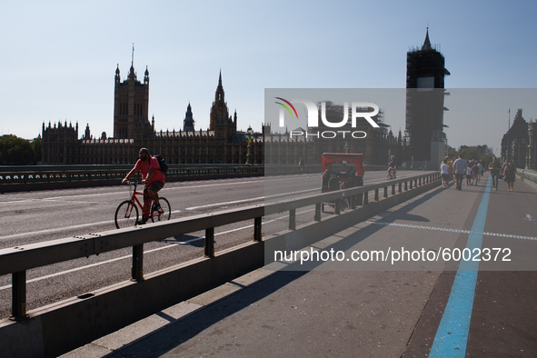 A cyclist crosses Westminster Bridge, heading south away from the Houses of Parliament in London, England, on September 14, 2020. 