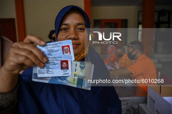 A resident shows the Cash Social Assistance (BST) money he just received at the Palu Post Office, Central Sulawesi Province, Indonesia on Se...