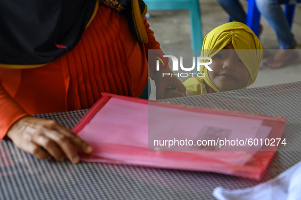 A child follows his parents who will collect Cash Social Assistance (BST) at the Palu Post Office, Central Sulawesi Province, Indonesia on S...