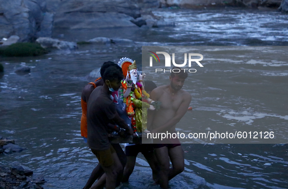 A Hindu Devotees carry an idol of Lord Vishwakarma to conclude the Vishwakarma Puja on the banks of the holy Bagmati River. amid Covid-19 pa...