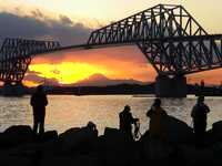 Tokyo Gate Bridge is silhouetted against the setting sun in front of Mount Fuji in Tokyo May 22, 2015. (