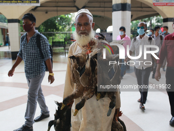 A man carries ducks as he arrived at Kamolapur railway station to sell them in the capital in Dhaka, Bangladesh on September 20, 2020. (