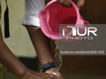 Teacher helps a student washing hands before attend class, in Guwahati, Assam, India on September 21, 2020 as schools reopened after more th...