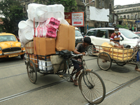 Labourers warring face mask  push a cycle van loaded Goods on the Street in Kolkata,India on Tuesday, September 22,2020. The nation of 1.3 b...