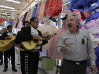 Mariachis walk the aisles of the Mixcalco Market to celebrate the 63rd anniversary of the La Merced and Jamaica Markets, which were founded...