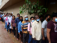 Bangladeshi migrant workers who work in Saudi Arabia gather in front of the Biman Bangladesh Airlines office to collect air tickets to go ba...