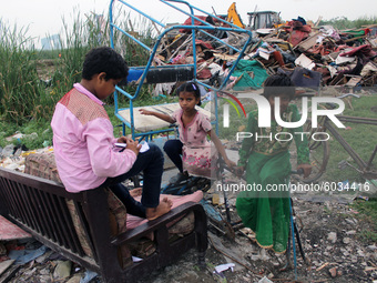 Children are seen outside demolished slum dwellings after demolition drive by the Delhi Development Authority (DDA) against encroachments at...
