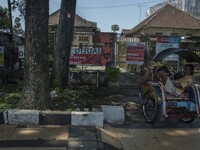 A pedicab driver fell asleep while waiting for passengers in front the fence of several houses that were sold through property sales service...