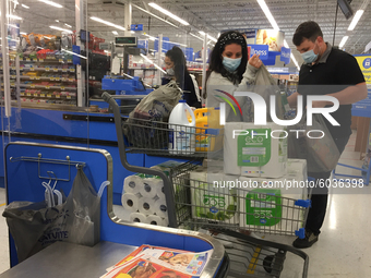 Couple buying paper towels at a Walmart store as panic buying resumes ahead of the second wave of the novel coronavirus (COVID-19) outbreak...
