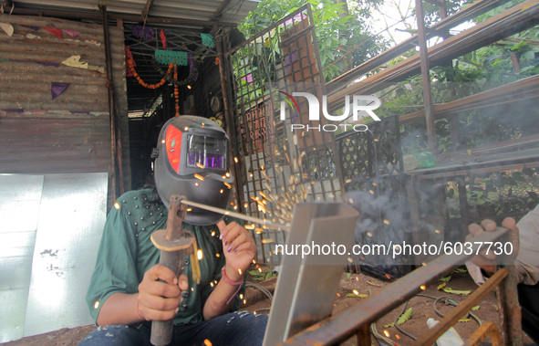 A girl works at a fabrication shop as she is welding iron grills to earn money to maintain her livelihood after lockdown relaxation in betwe...