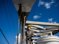 Nepalese construction worker paint a newly built bridge at Kathmandu, Nepal on Sunday, September 27, 2020. (