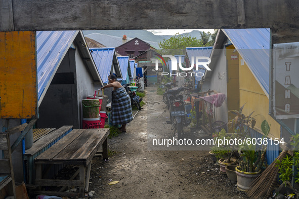 A resident of a disaster victim works in front of the temporary shelter he occupies in Palu, Central Sulawesi Province, Indonesia on Septemb...