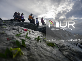 Families of disaster victims sow flowers at the former tsunami site on Talise Beach, Palu, Central Sulawesi Province, Indonesia on September...