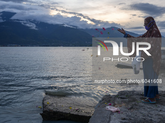 A mother sows flowers at the former tsunami site on Talise Beach, Palu, Central Sulawesi Province, Indonesia on September 28, 2020. The flow...