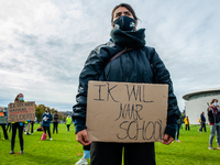 A woman is holding a placard that says I want back to school, during the students protest for more physical attendance classes, in Amsterdam...