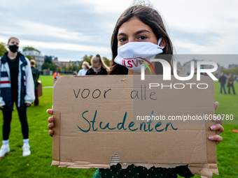 A little girl is holding a placard that says I want back to school, during the students protest for more physical attendance classes, in Ams...