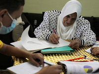 Palestinian teacher Ekram el-astal, 80, teaches her neighbours' students an Maths language lesson as schools are shut due to the coronavirus...
