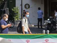 An Iranian man wearing a protective face mask looks on as he walks along an avenue in northern Tehran while the new coronavirus (COVID-19) d...