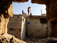 Palestinian children are seen on the roof of their house in Al-Shati refugee camp in Gaza City on October 8, 2020. (