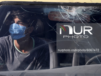 A young Palestinian man looks from behind the windows of a car in Gaza City, on October 8, 2020. (