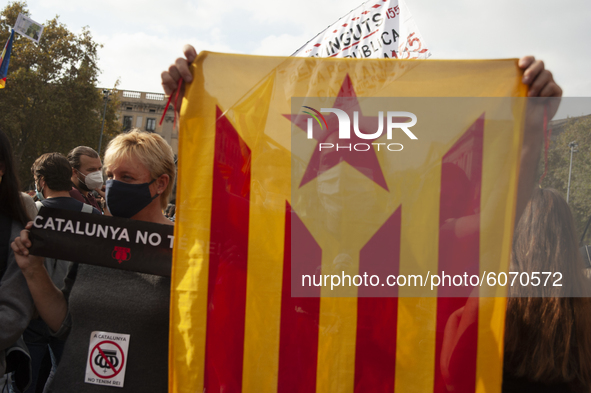 A man holds a separatist flag in Barcelona, Spain, on October 9, 2020. Thousands of people have demonstrated against the visit of Felipe IV...