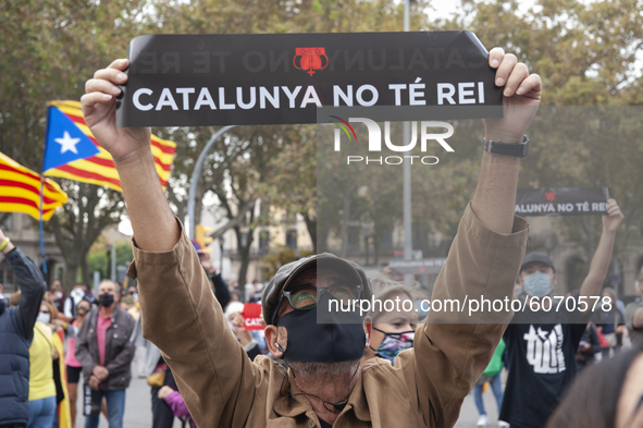 A man holds a banner that reads, Catalonia has no King during the visit of the monarch Felipe IV in Barcelona, Spain, on October 9, 2020. Th...