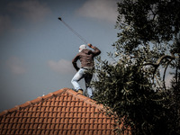 A Palestinian protester uses a sling to hurl stones towards Israeli soldiers during a protest against the Jewish settlement of Ofra, in the...