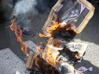 Anti-monarchy demonstrators burn a picture of the Spanish King during a protest against the visit of King Felipe VI of Spain to Catalonia, i...