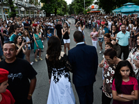 A young couple walks hand in hand during the high school graduates parade through the Bulgarian town of Svilengrad on May 26, 2015 (