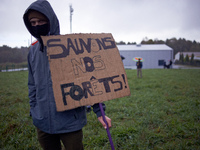 A man holds a cardboard reading 'Let's us save our forest' on the place where the sawmill will be built in Lannemezan. Several associations,...