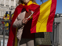 A group of people with flags of Spain attend the during the event organized on the occasion of the National Holiday Day, in Madrid this Mond...