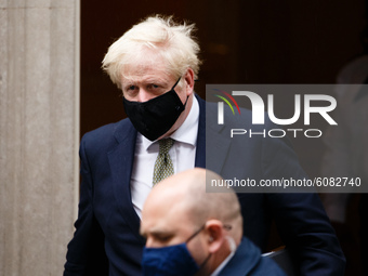 British Prime Minister Boris Johnson wears a face mask as he leaves 10 Downing Street headed for the Houses of Parliament in London, England...