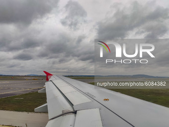 Wing view of the taxiway and runway before take off with clouds. Flying with Lauda Airbus A320 airplane with registration 9H-LMJ during the...