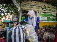 Residents weighs inorganic waste in the Bank Sampah (Garbage Bank) Guyub Rukun to exchange money or groceries such as rice and sugar in Kemi...