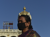 A woman wears a mask with a dome of a building over her head amid coronavirus emergency in Kolkata, India, 13 October, 2020. India's coronav...