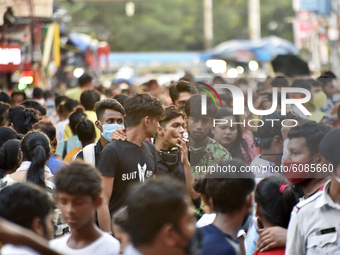 A boy smokes among the crowd in a shopping area, where no social distancing is maintained. People gathers for shopping before the biggest fe...
