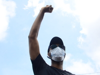A END SARS protester hold his fists in the air showing his support of the ongoing protest against the harassment, killings and brutality of...