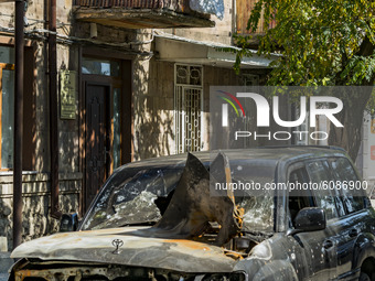 A woman in her balcony looks a destroyed car by azeri rocket during the shelling of Azerbaijan  army over Stepanakert, capotal of Nagorno Ka...