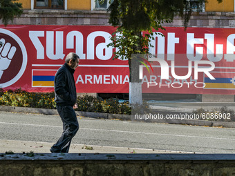 A man walks through the streets of Stepanakert, capital of Nagorno Karabakh, under a huge banner with the flags of Armenia and Nakgorno Kara...