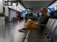 Passengers wearing facemasks, face shields, gloves and other safety measures are seen in the airport terminal, at the F Gates area of Vienna...